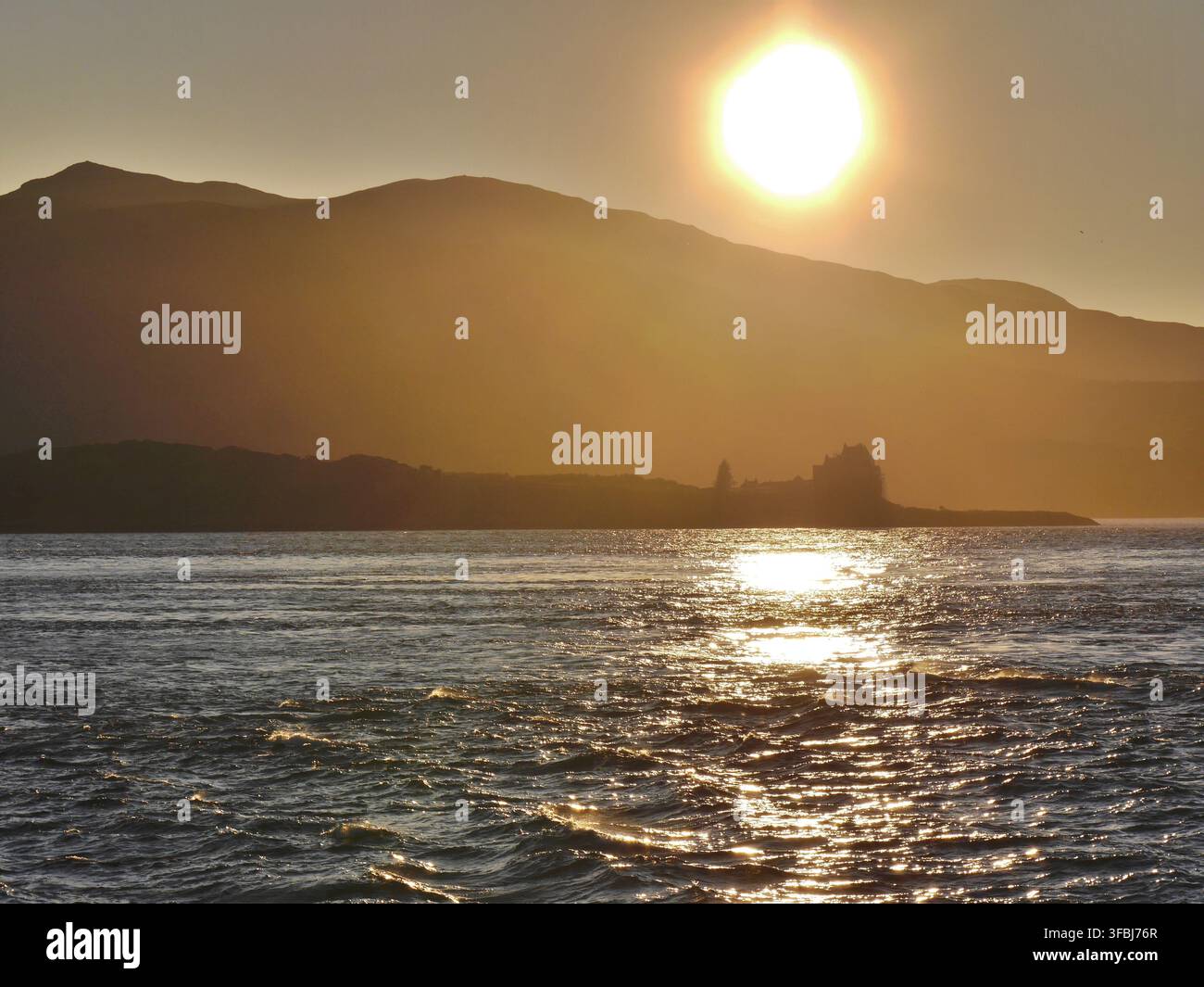 Sole che tramonta sulle montagne e sulla baia, Oban, Scozia. Foto Stock