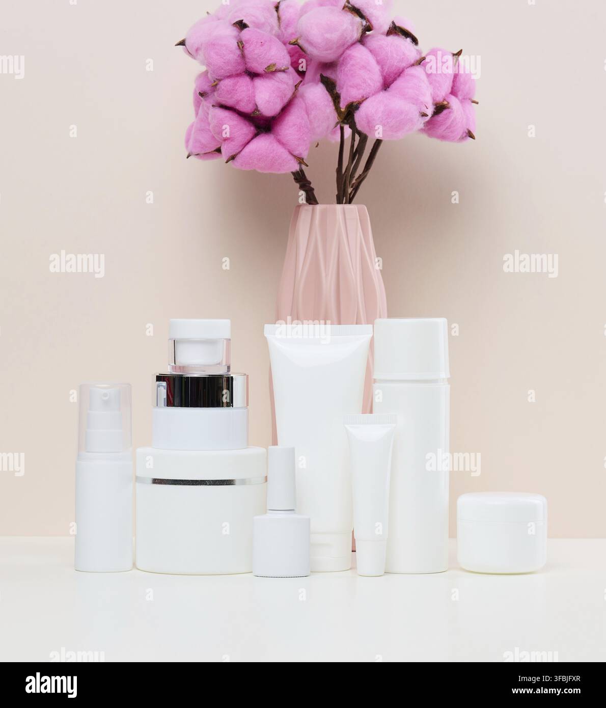 Vasetti e tubi in plastica bianca per cosmetici liquidi su fondo bianco. Branding, pubblicità Foto Stock