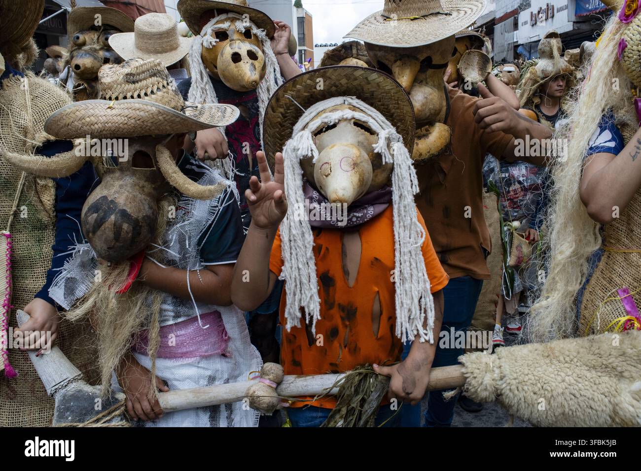 Vista dei partecipanti che indossano maschere tradizionali in zucca e cappelli di paglia durante un festival culturale a Michoacan, Messico Foto Stock