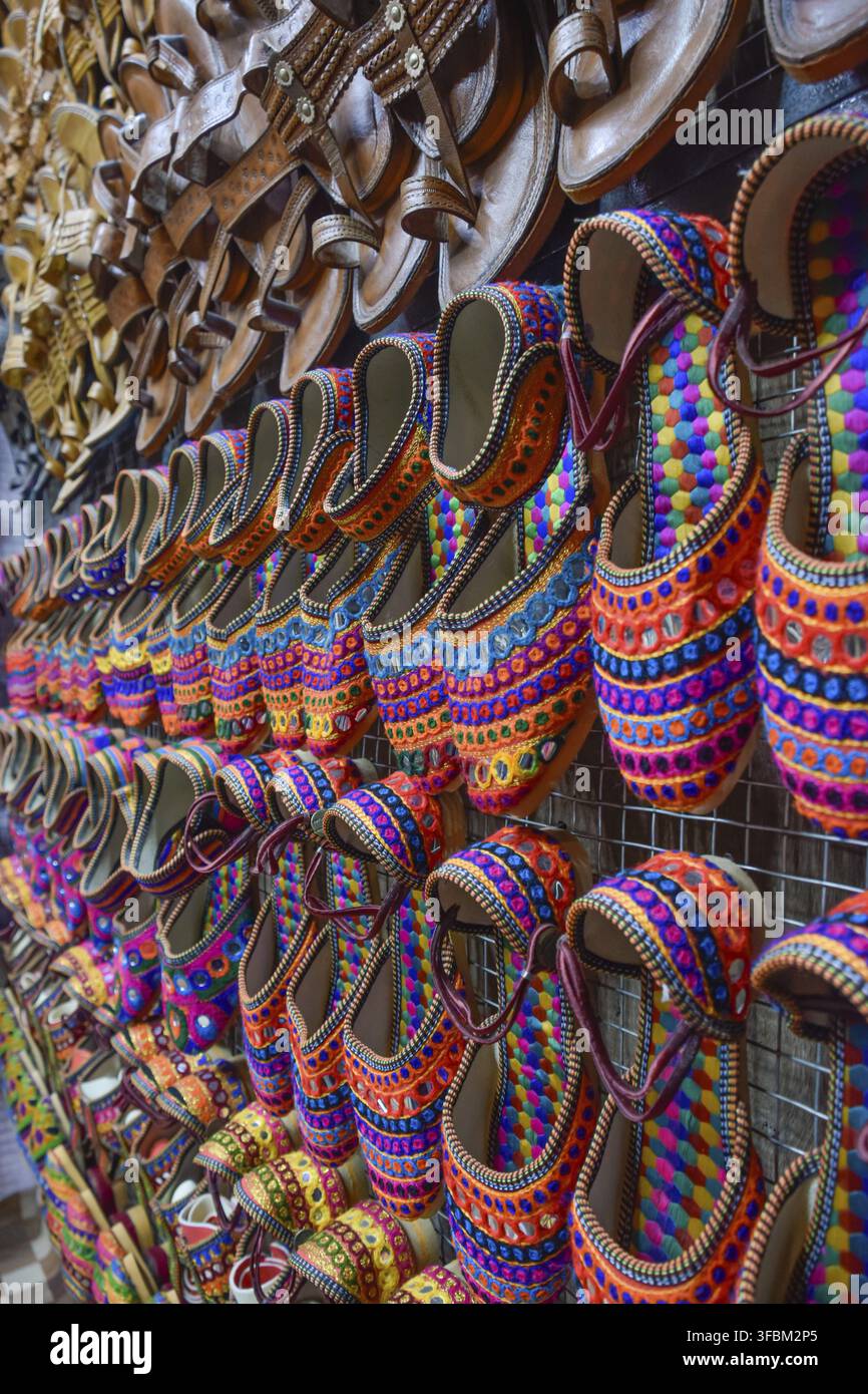 Scarpe tradizionali di Pushkar Rajasthan in diversi colori nei mercati di strada. India Foto Stock