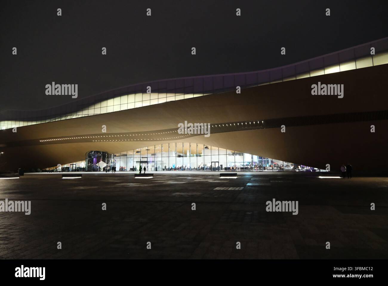 Helsinki, Finlandia-30 novembre 2025: ingresso illuminato e facciata in legno moderna ondulata della Biblioteca Centrale di Helsinki Oodi di notte Foto Stock