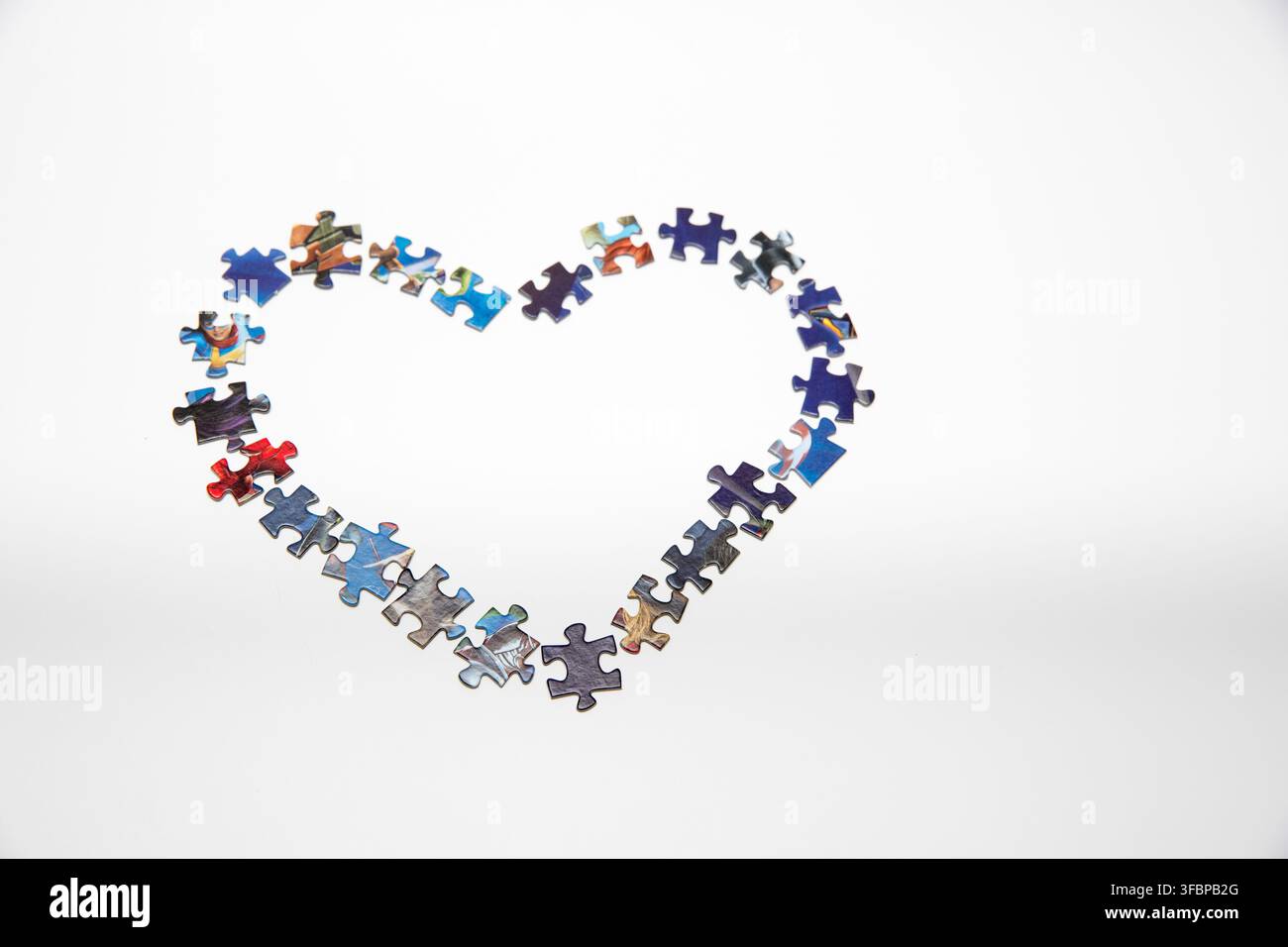 Puzzle di pezzi disposti in forma di cuore Foto Stock