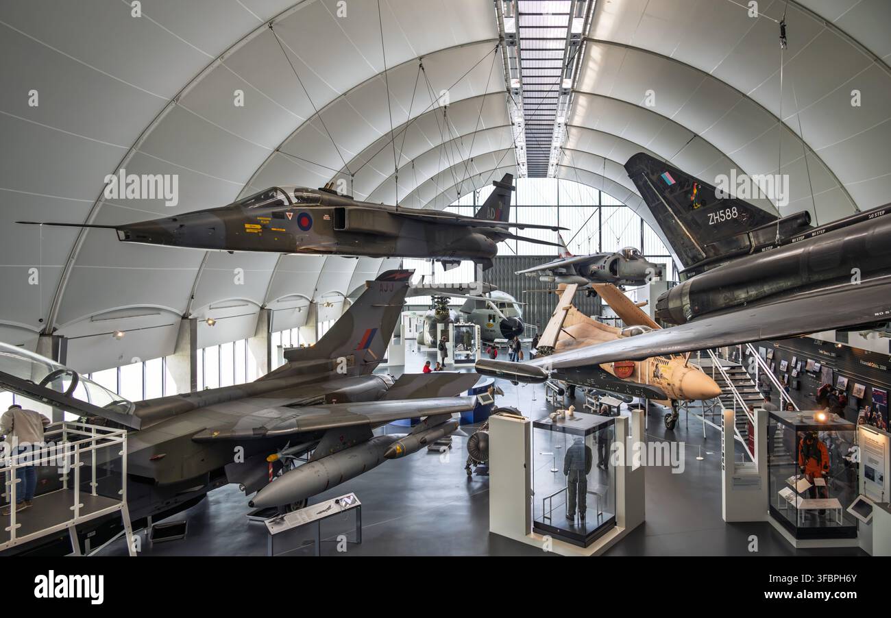 Una vista ampia degli aerei da combattimento sospesi nella galleria espositiva "Età dell'incertezza" nell'Hangar 6 del Royal Air Force Museum di Londra Foto Stock
