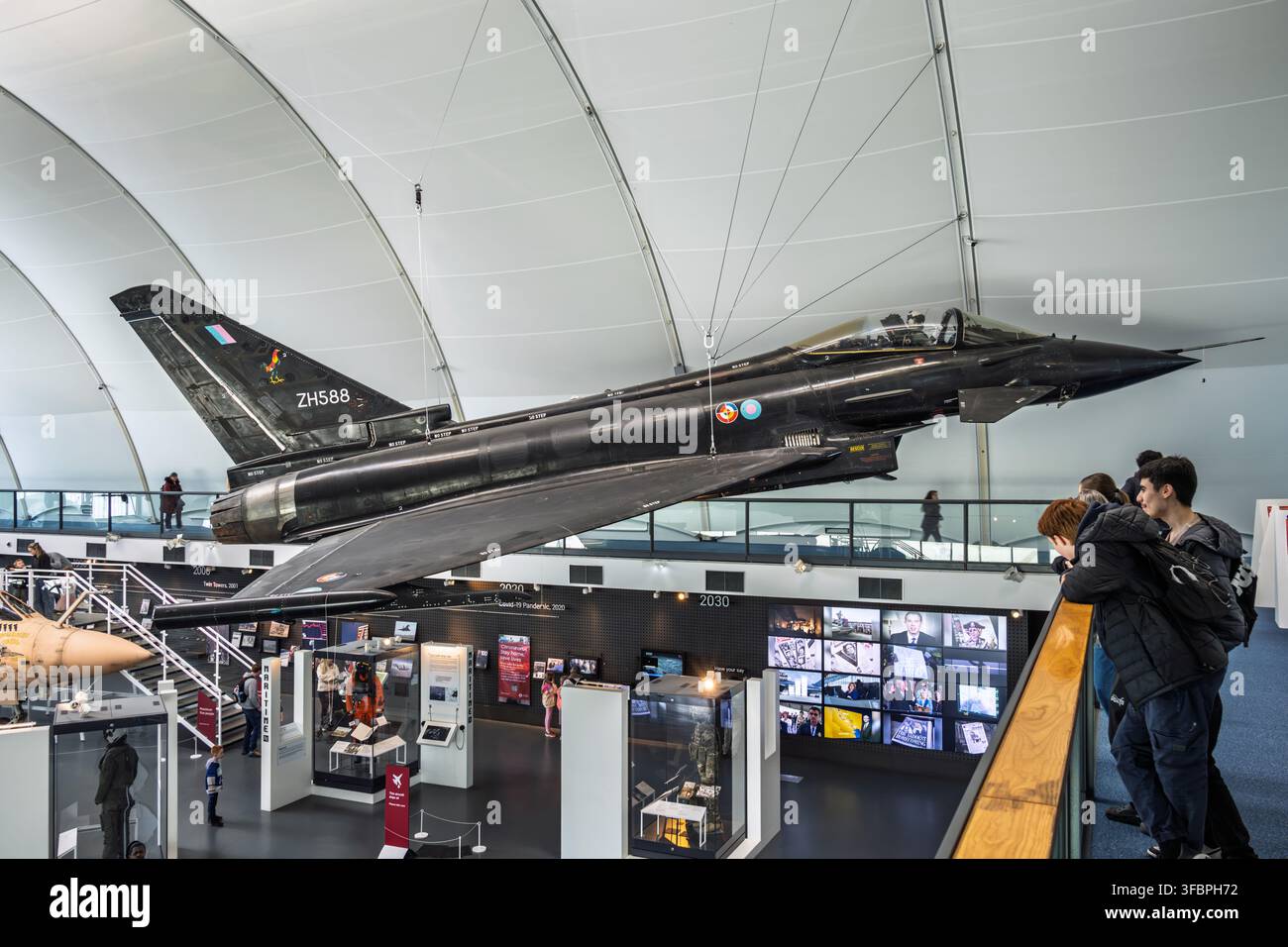 Visitatori che osservano un prototipo nero dell’Eurofighter Typhoon (ZH588) nella galleria "Age of Uncertainty" del RAF Museum di Londra a Hendon Foto Stock
