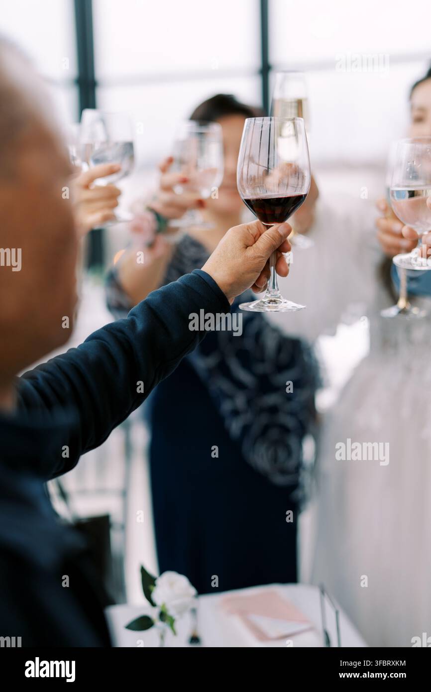 Brindisi di gruppo con bicchieri di vino durante una celebrazione Foto Stock