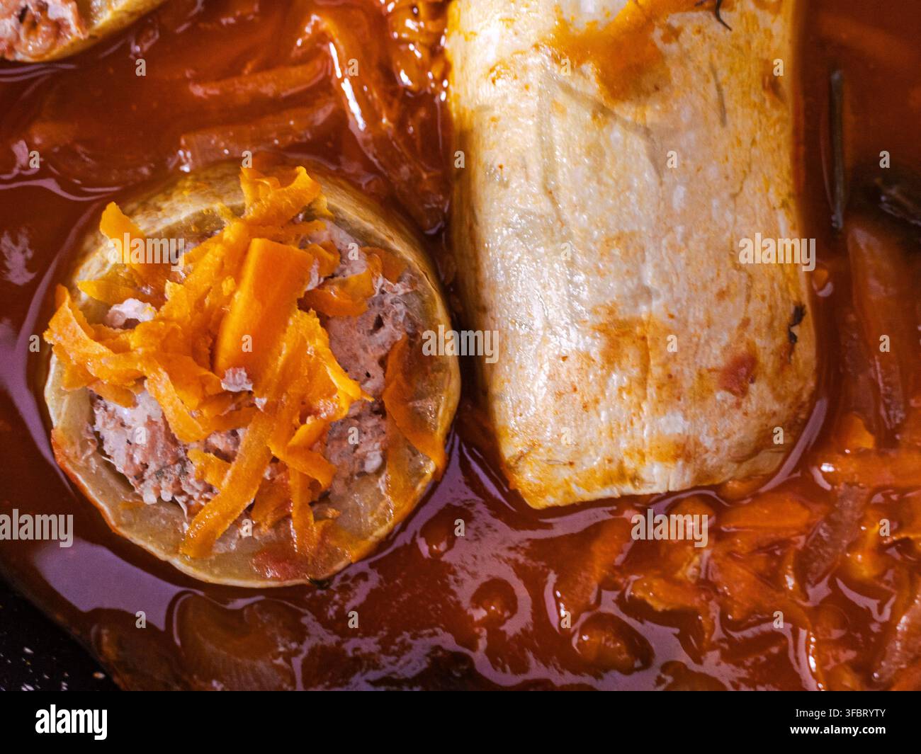 Involtini di cavolo ripieni in salsa di pomodoro con ripieno di carote e carne, primo piano di un pasto tradizionale fatto in casa. Foto Stock