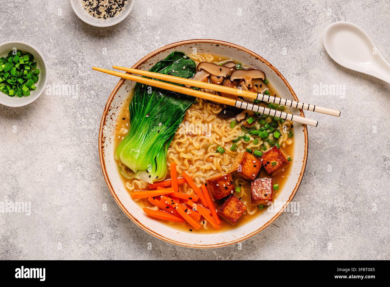 Zuppa miso ramen con noodles servita con tofu, bok choy, carote e funghi in una ciotola. Foto Stock