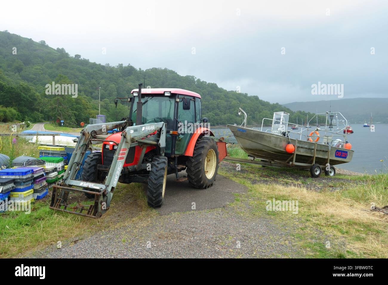 Trattore e barca da pesca tradizionale scozzese sulla riva di Loch Linnie, Scozia. Foto Stock