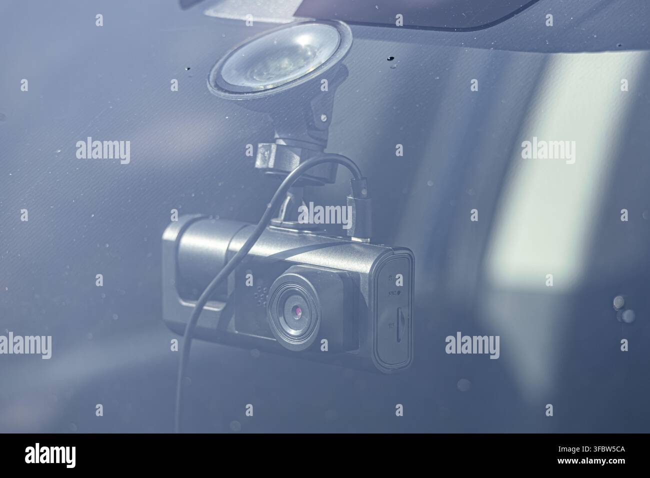 Una moderna telecamera da cruscotto nera montata sul parabrezza di un'auto con una ventosa per la sicurezza del veicolo e la registrazione degli incidenti. Foto Stock