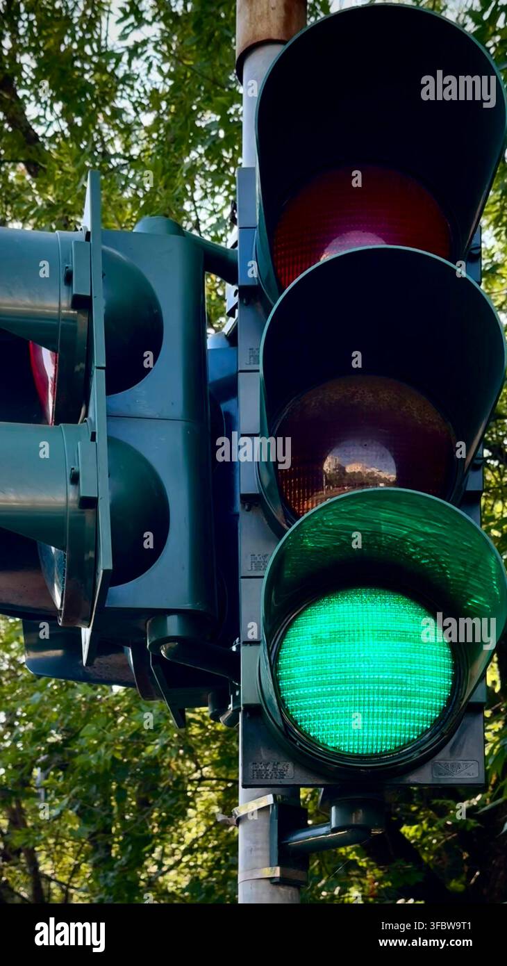 Semafori verdi che brillano a un incrocio cittadino, illustrando il flusso del traffico, il movimento, la sicurezza stradale e i trasporti urbani. Foto Stock