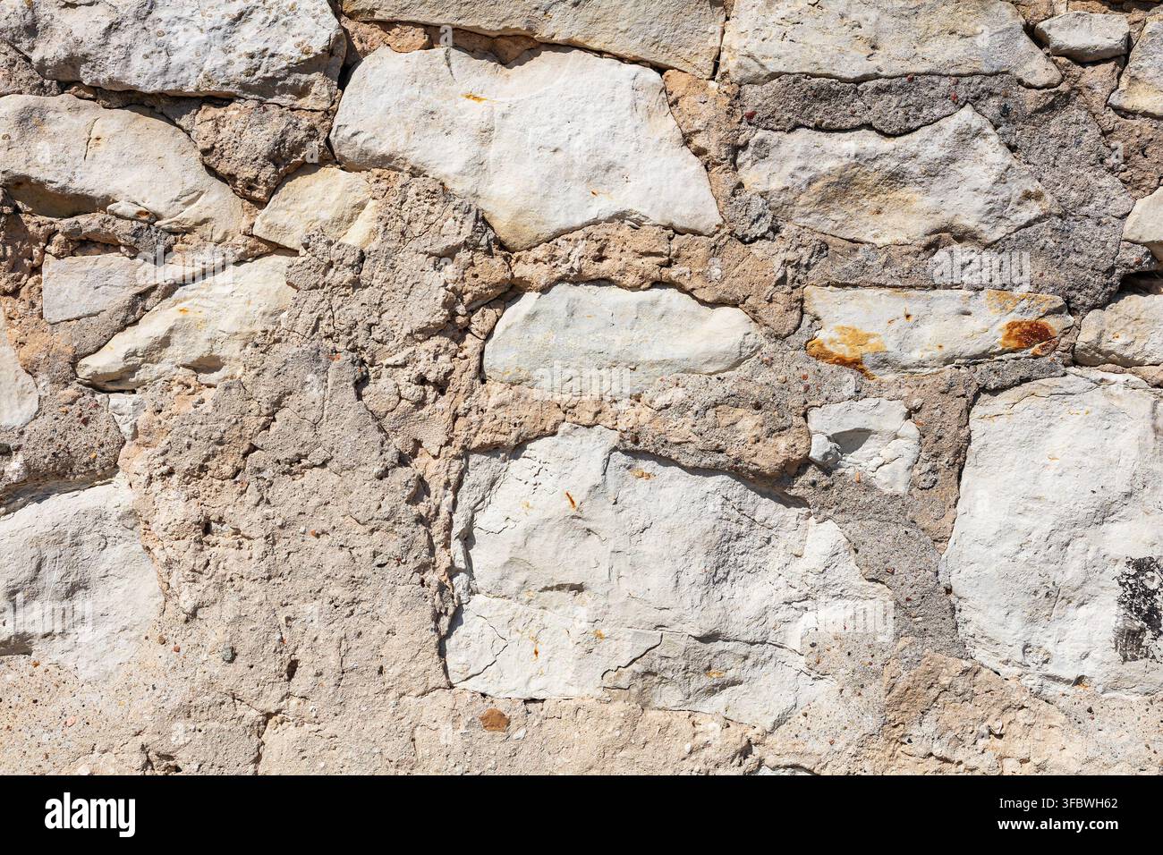 Texture di muro in pietra bianca rustica con giunti di malta ruvidi Foto Stock