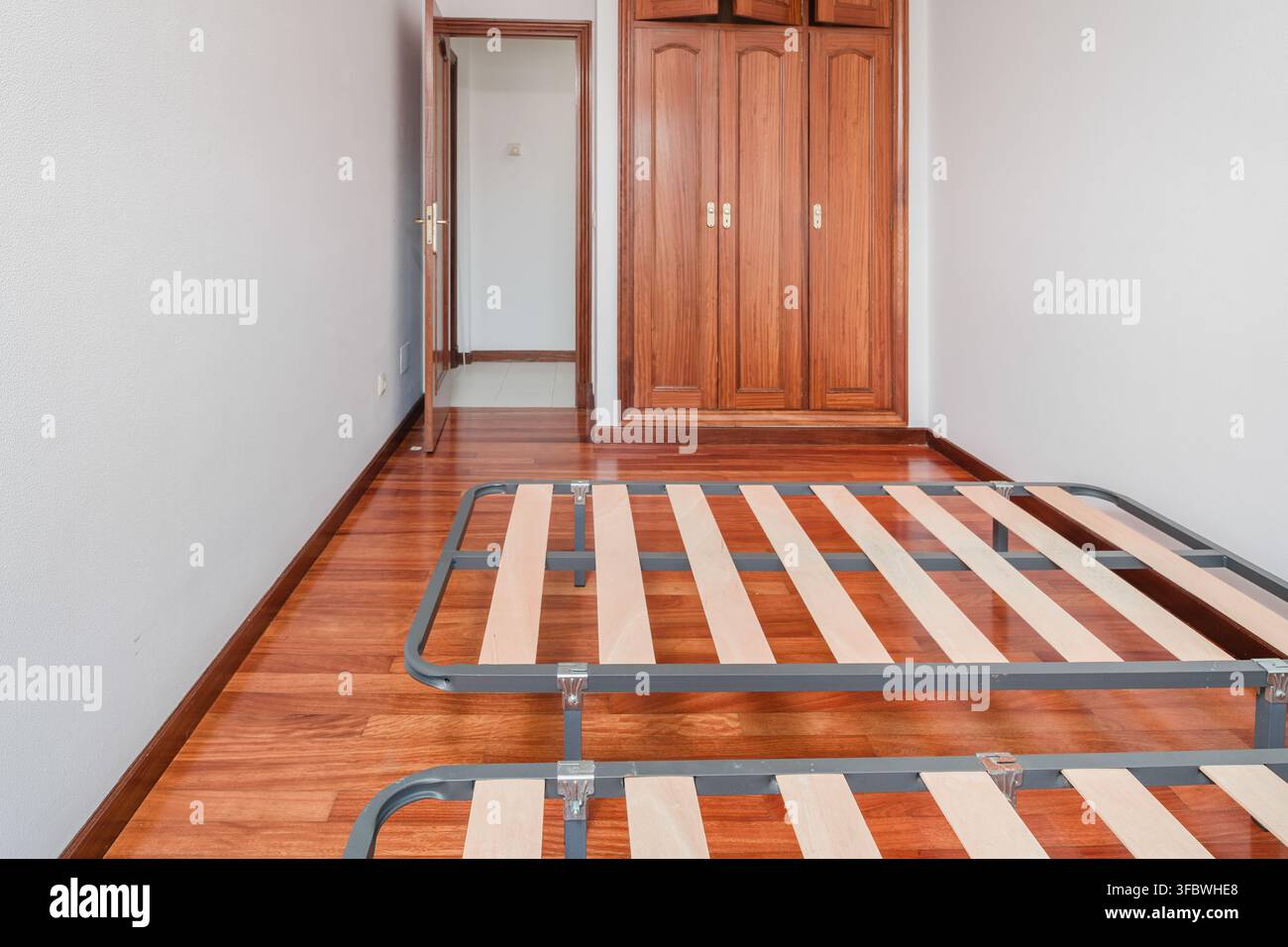 Camera da letto vuota con letti e pavimento in legno Foto Stock