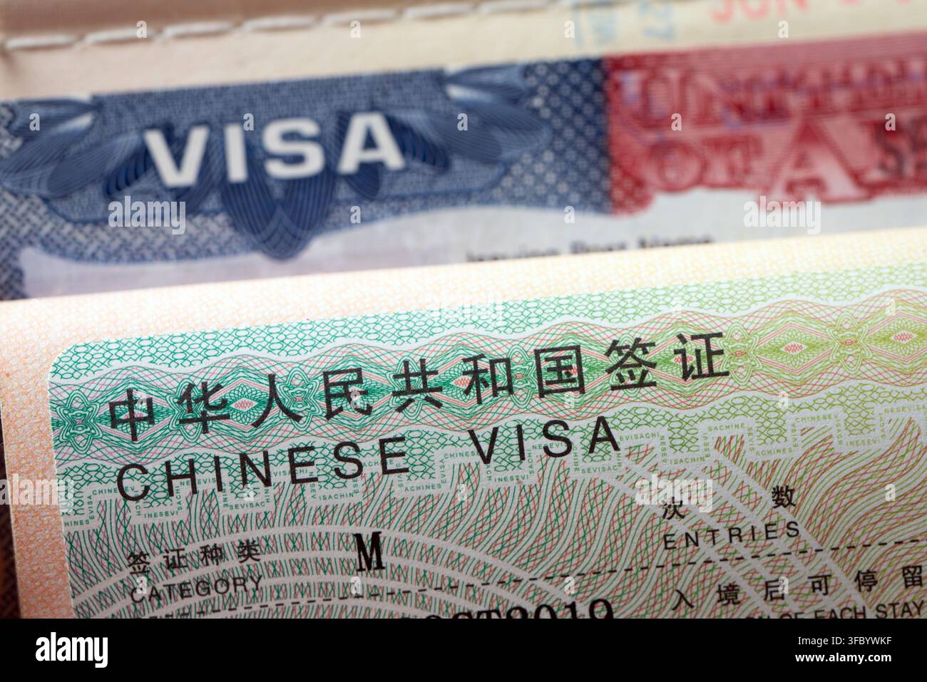 Sia un visto cinese che un visto per gli Stati Uniti nelle pagine aperte del passaporto. Immagine ideale per relazioni internazionali, viaggi globali, affari diplomatici, commercio, permessi di viaggio e argomenti di immigrazione. Foto Stock