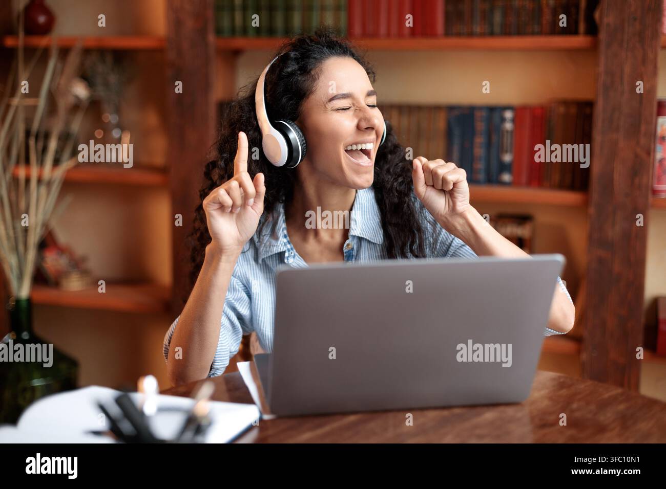 Donna che ascolta la musica online con le cuffie Foto Stock
