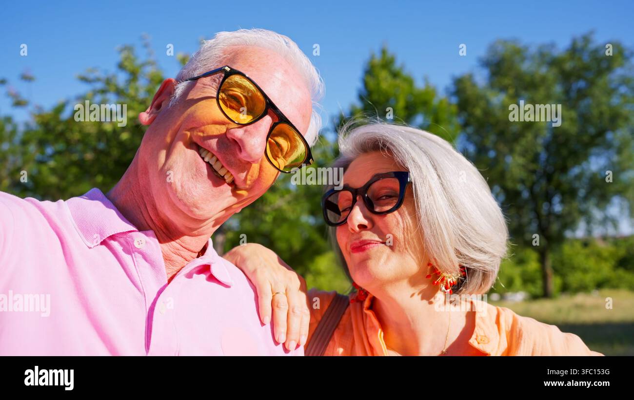 Coppia di anziani felici che sorride per un selfie in una giornata di sole Foto Stock