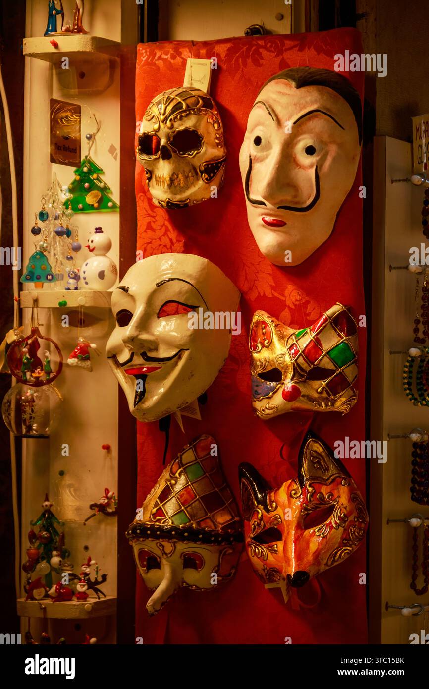 Maschere colorate fatte a mano, volti in ceramica dipinti e braccialetti di perle esposti su una tavola di un banco del mercato rosso in un negozio di souvenir stretto. Foto Stock