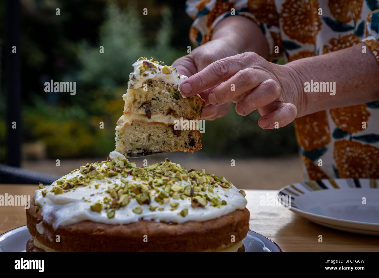 Una torta appena sfornata viene tagliata pronta per essere mangiata Foto Stock