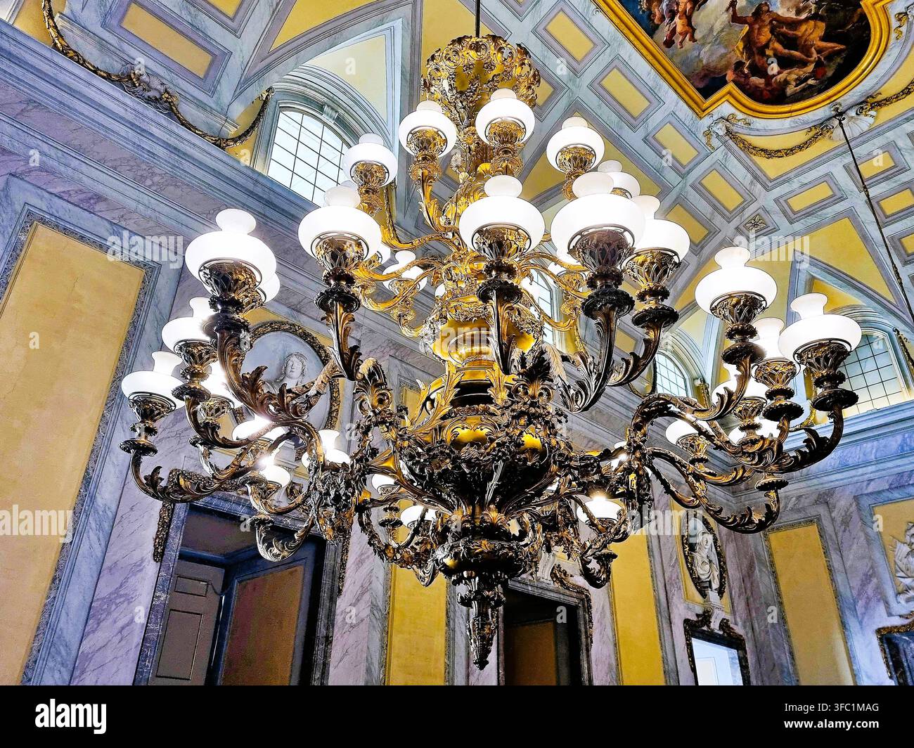 Un lampadario dorato monumentale all'interno della sala Alabardieri del Palazzo Reale di Caserta, Italia Foto Stock