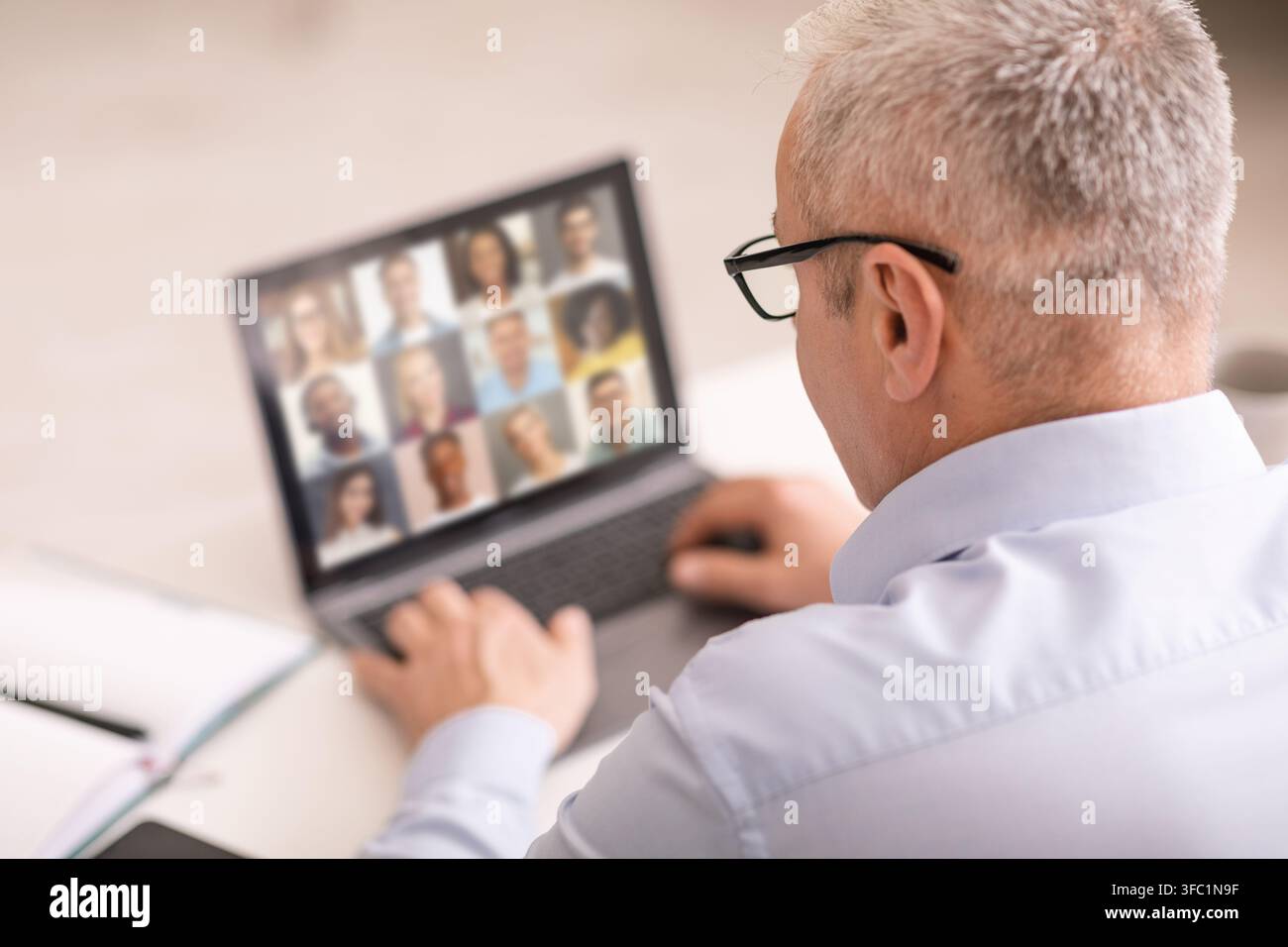 Indietro Vista di uomo d'affari senior che ha una conferenza Web con i suoi dipendenti, Collage Foto Stock