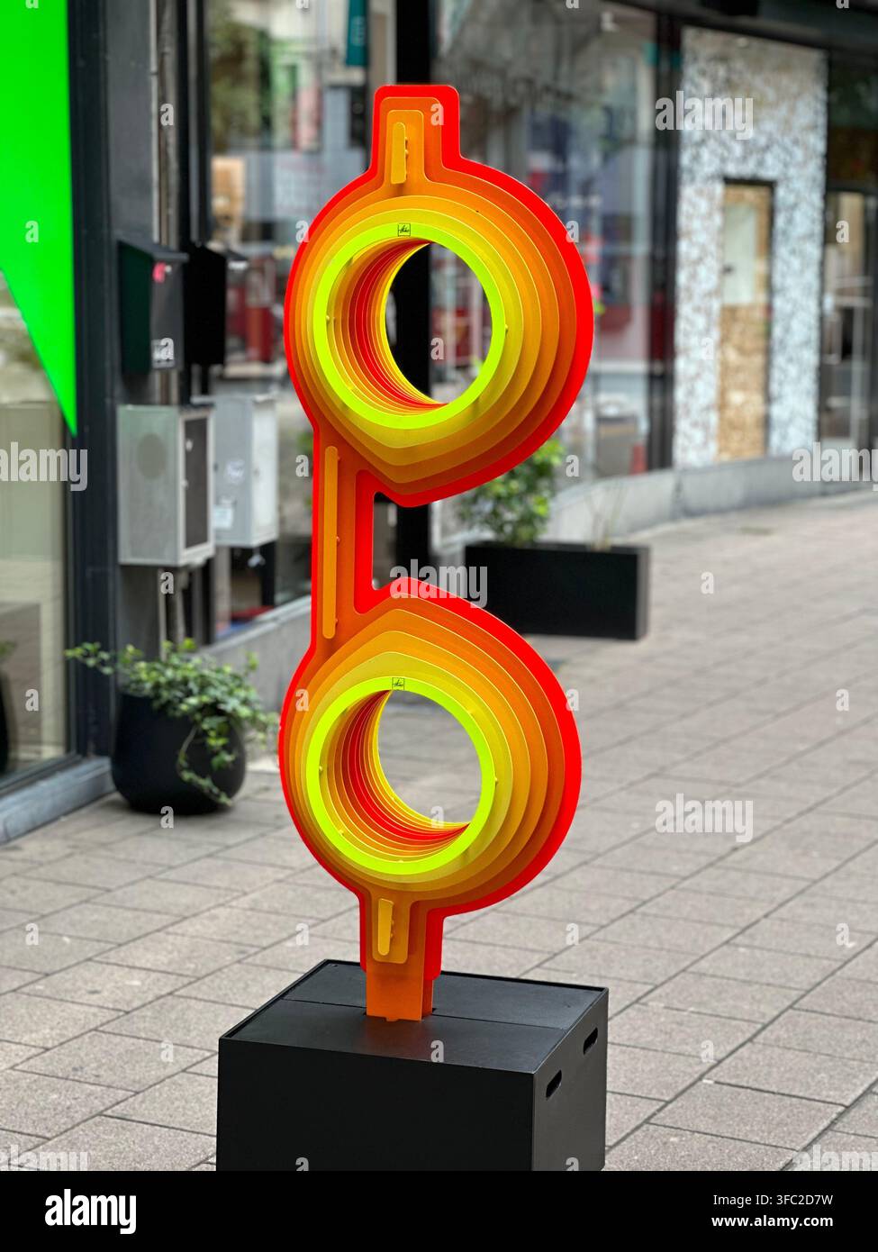 Scultura d'arte moderna astratta vibrante con cerchi concentrici annidati su una strada cittadina. Scultura di arte urbana contemporanea sorprendente con strati co - Immagine stock catturata con smartphone