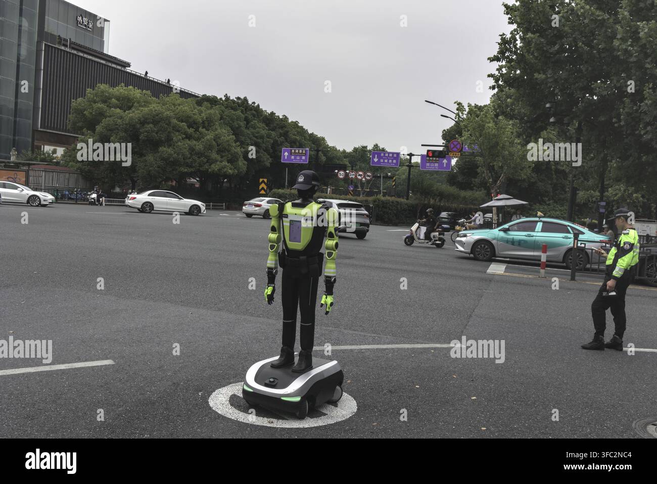 Robot umanoide che dirige il traffico accanto a un agente di polizia a Hangzhou, Cina Foto Stock
