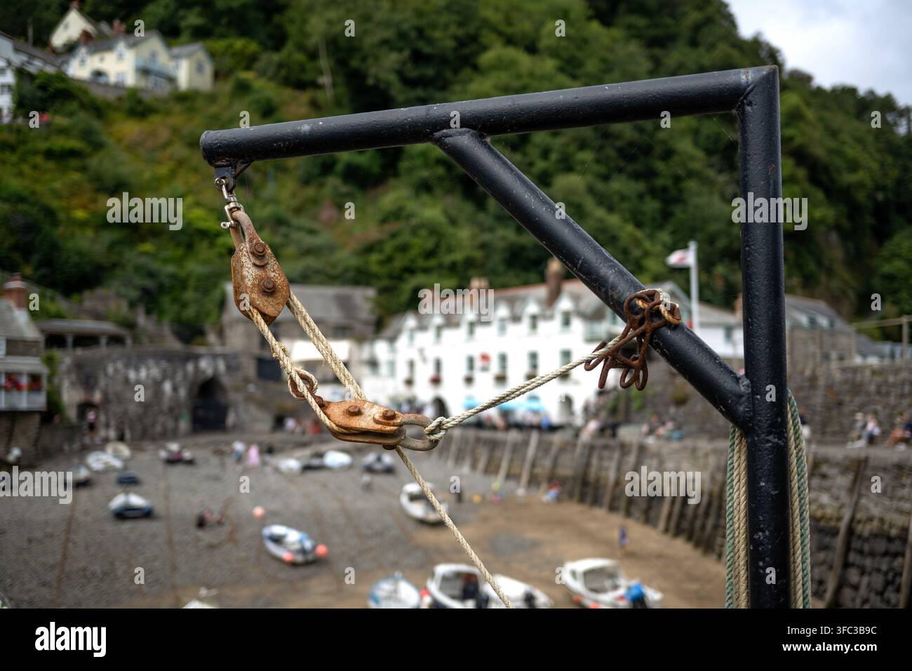 CLOVELLY, DEVON - 27 LUGLIO 2026: Primo piano di un paranco con carrucola e edifici del villaggio sullo sfondo Foto Stock