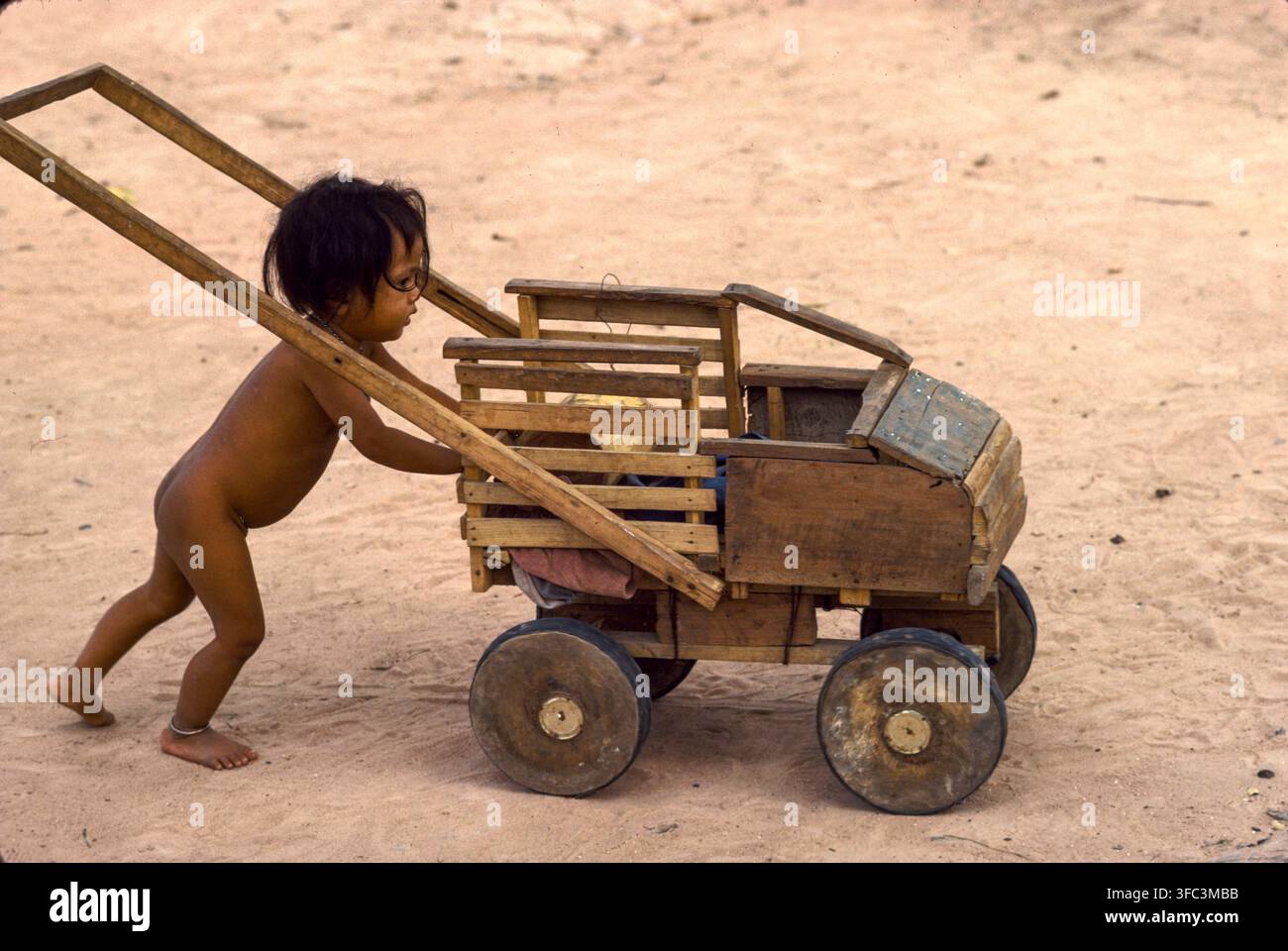 Un bambino gioca con un camion giocattolo fatto in casa al Camp 007, al confine tra Thailandia e Cambogia, nov. 1979. Questo campo controllato dai Khmer Serei ospitava 80.000 rifugiati cambogiani, nov. 1979 Foto Stock