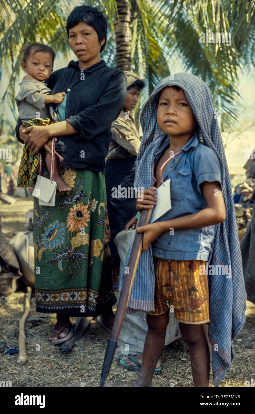 Bambini rifugiati aspettano mentre le loro famiglie fanno la fila per il trasferimento di cambogiani dal Campo 007 al campo profughi di Khao-I-Dang, Thailandia, 1 novembre 1979. Aperto dopo l'invasione del Cambogia da parte del Vietnam, il campo ha ospitato decine di rifugiati cambogiani ed è diventato il più grande centro di rifugiati al confine. Foto Stock