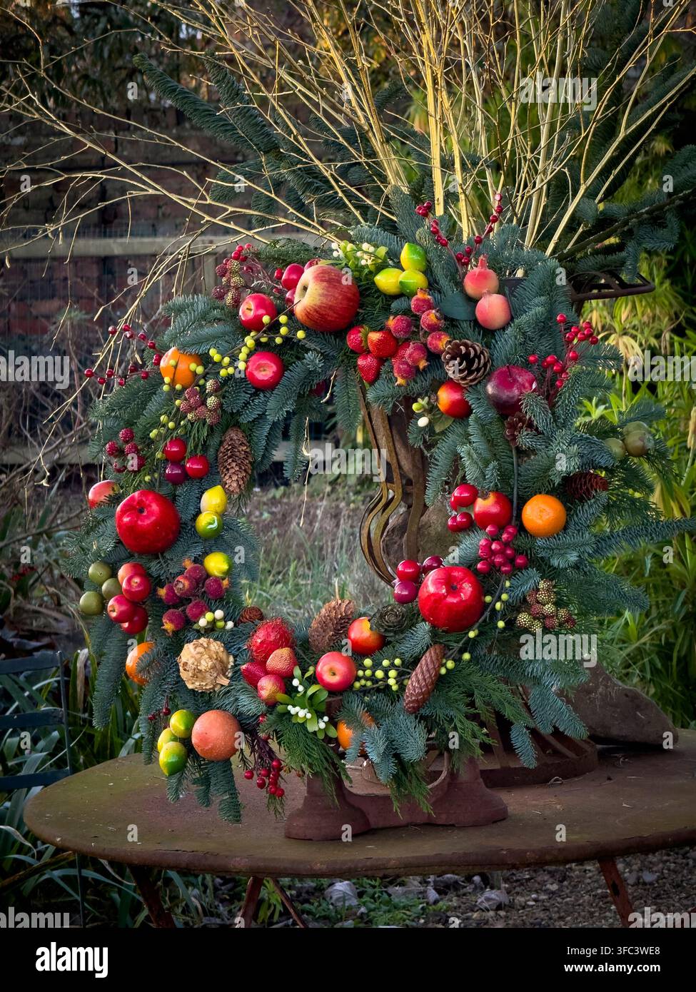 Ghirlanda natalizia decorata con frutta, bacche e pigne nell'area di Heslington e dell'Università di York. Foto Stock