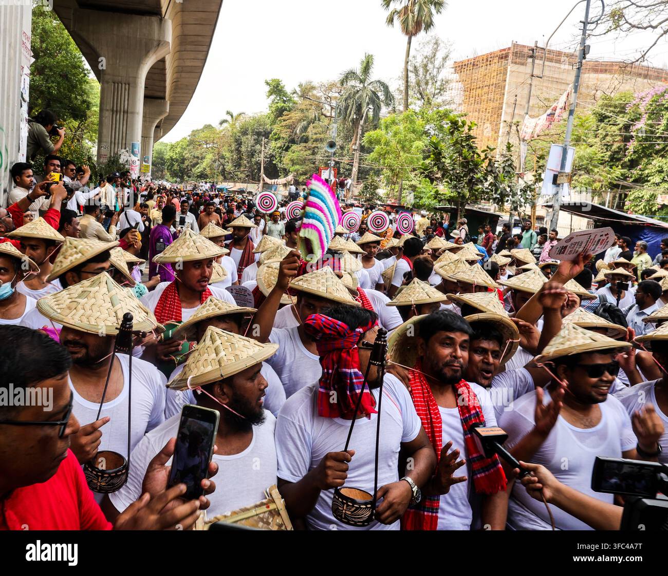 Dhaka, Division di Dhaka, Bangladesh - 14 aprile 2025: Vista di uomini che indossano cappelli coni tradizionali e camicie bianche che partecipano a una processione culturale Foto Stock