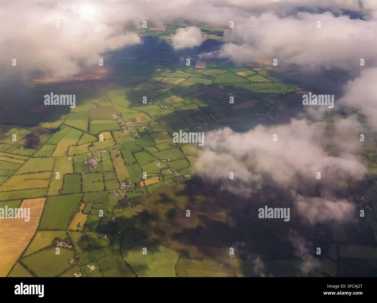 Vista aerea di terreni agricoli a chiazze parzialmente coperti da nuvole basse in un paesaggio agricolo rurale. Foto Stock