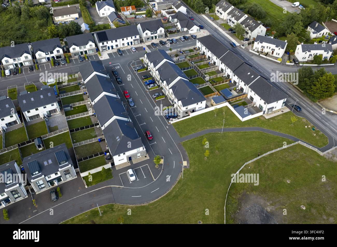 Vista aerea di un moderno complesso residenziale con file di case, vialetti, auto e prati verdi nel Donegal, Contea di Donegal, Irlanda. Foto Stock