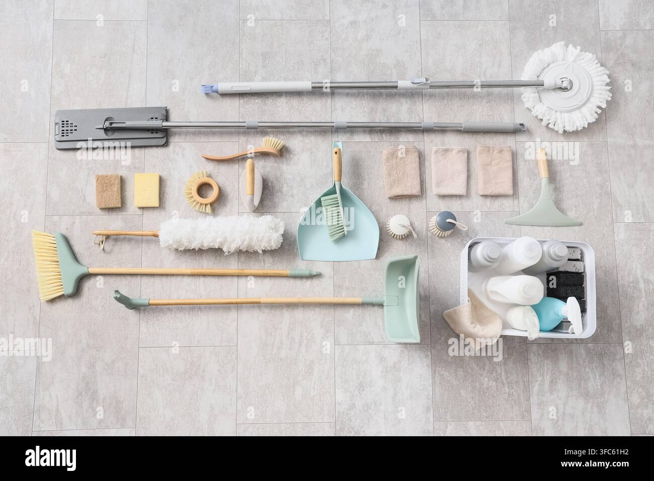 Concetto di pulizia della casa e faccende domestiche, vista dall'alto di vari prodotti e strumenti per la pulizia su un pavimento piastrellato Foto Stock