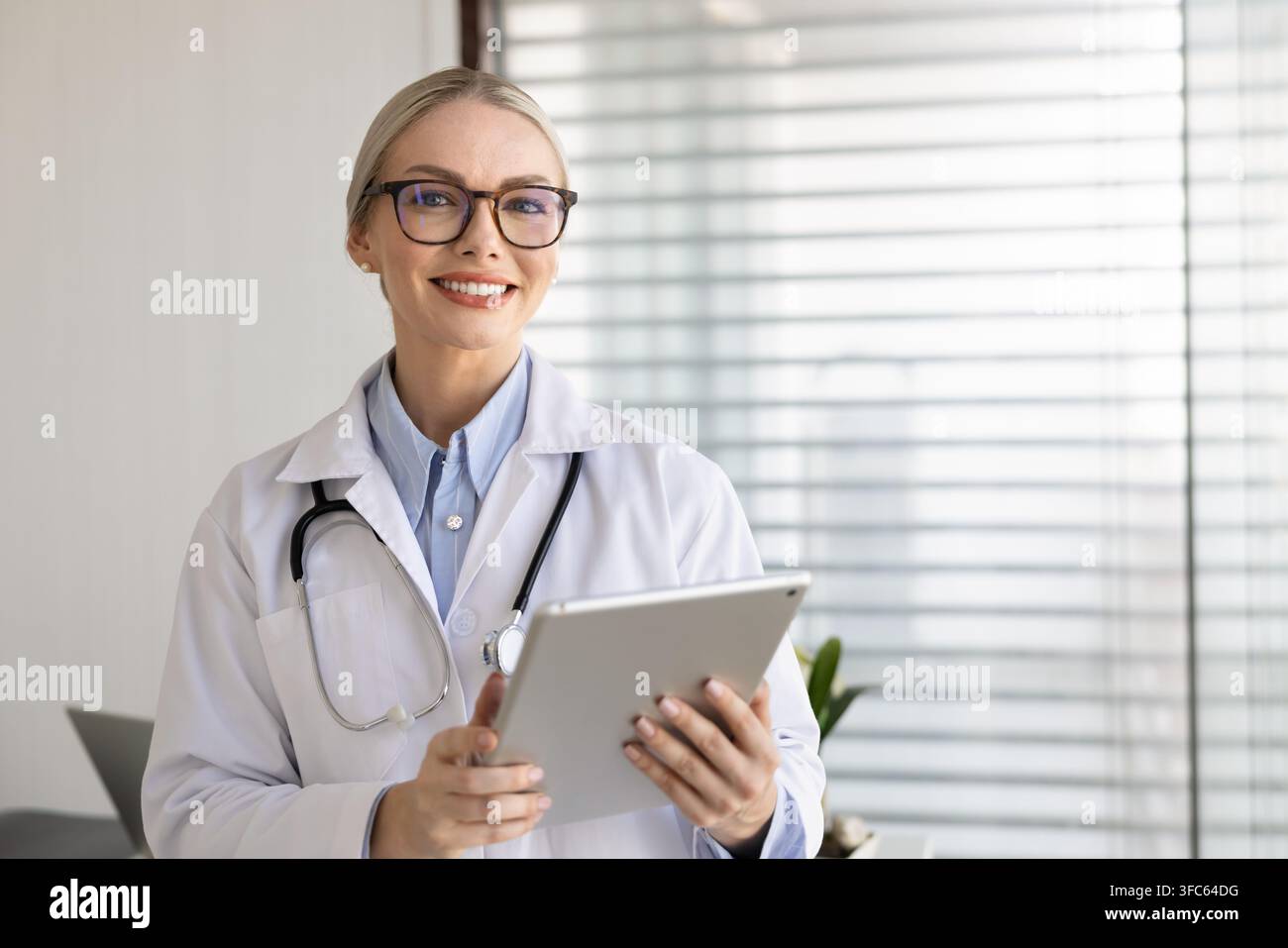 Ritratto di una dottoressa terapista donna in camice bianco che tiene un tablet digitale Foto Stock