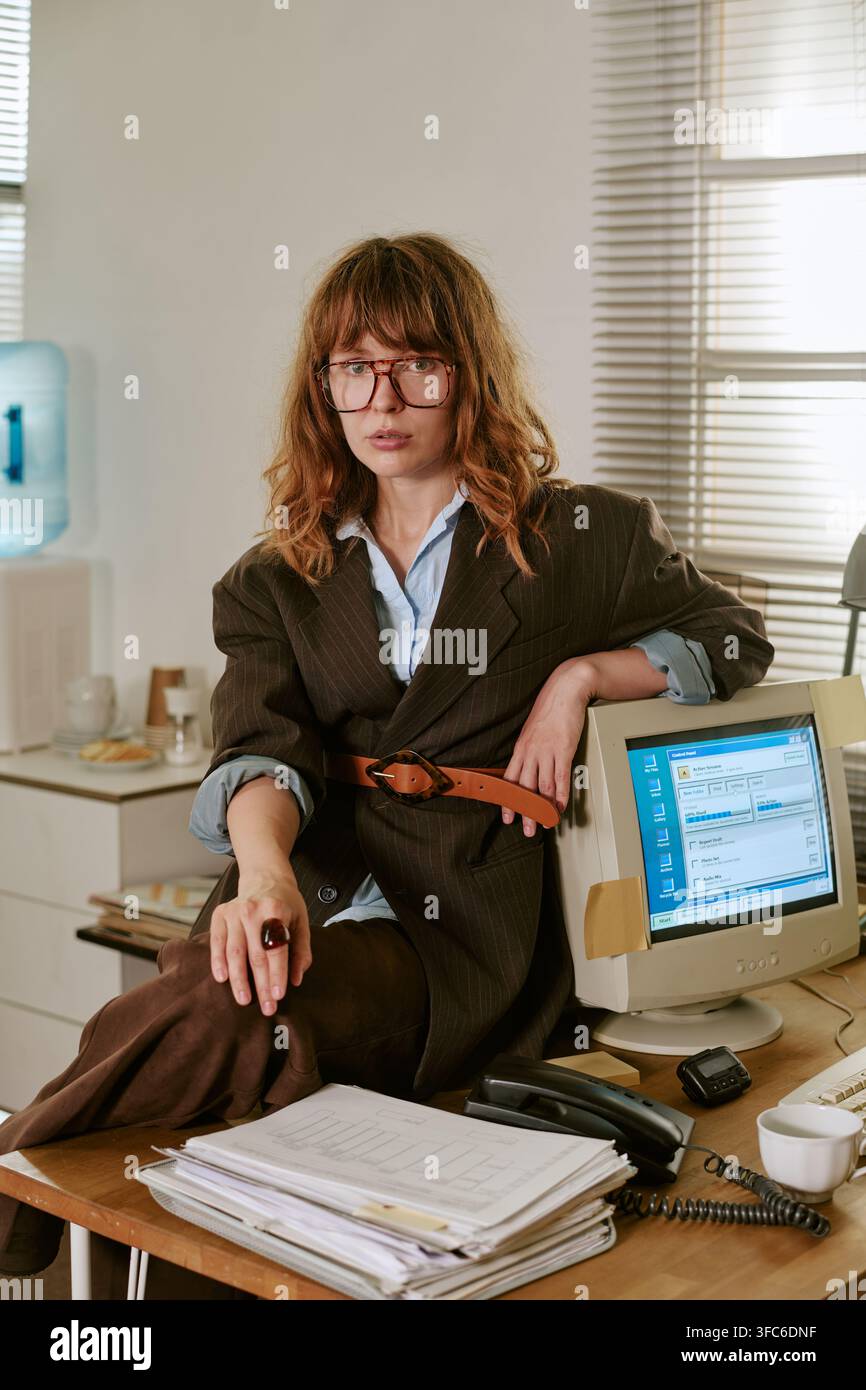 Ritratto di una donna seduta alla scrivania in un ufficio retrò Foto Stock