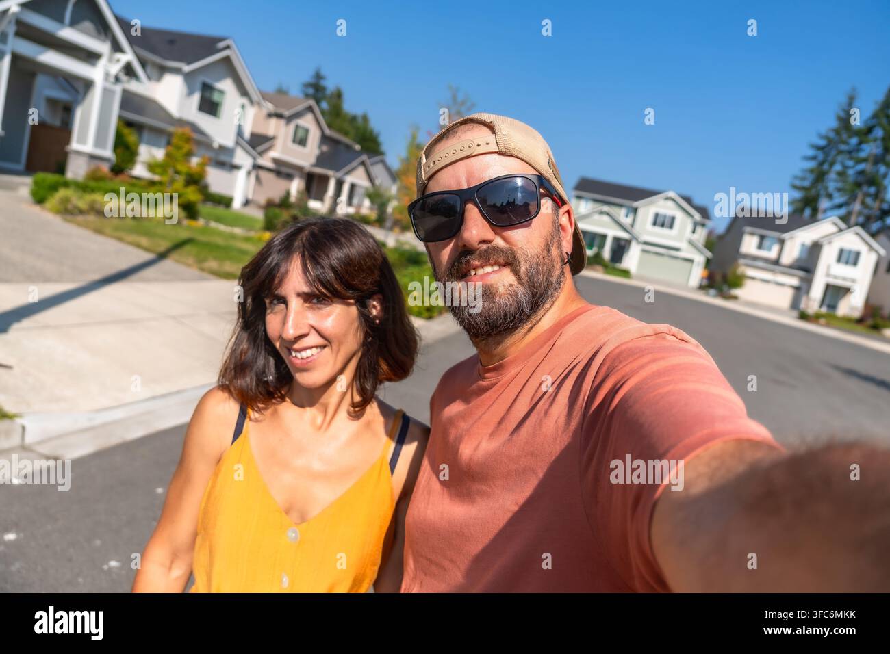 Coppia felice che scatta un selfie in una strada di periferia Foto Stock