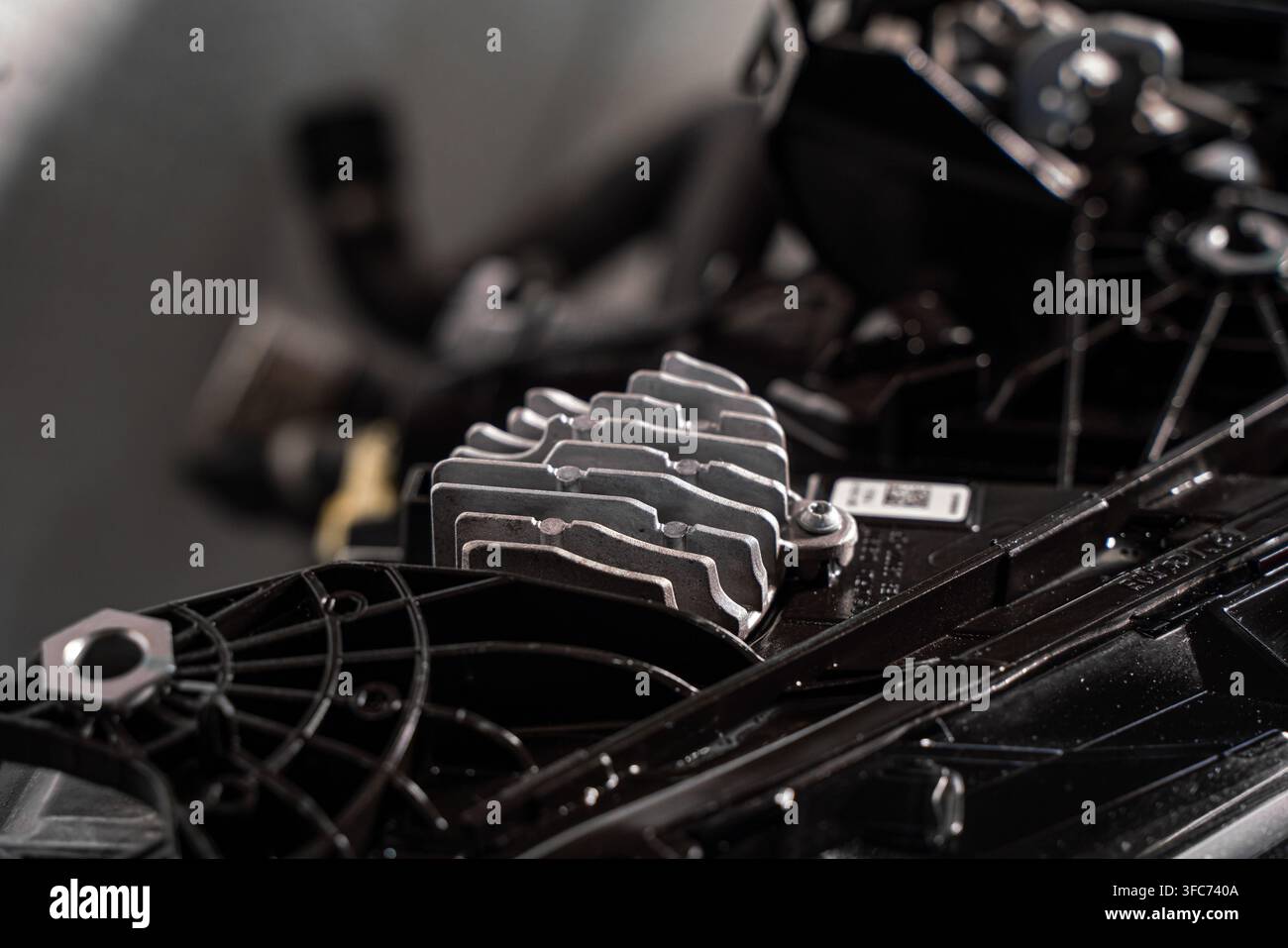 Prima di un modulo di controllo elettronico automotive con un dissipatore di calore in metallo montato vicino all'assemblaggio di raffreddamento anteriore di un veicolo. Foto Stock