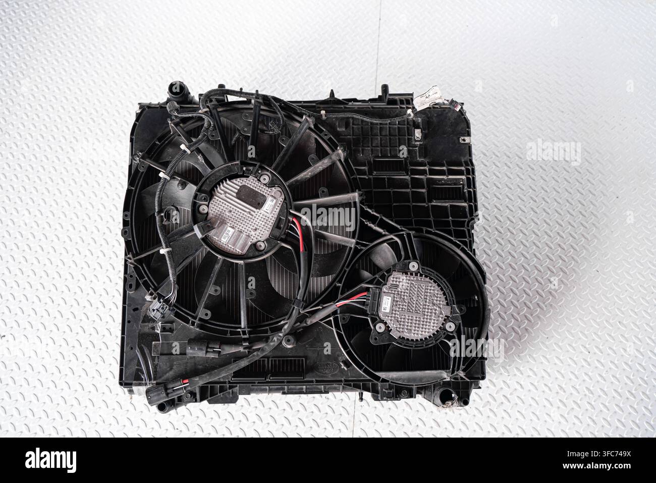 Un ventilatore di raffreddamento del radiatore automobilistico e il suo parabrezza con cablaggio è isolato su uno sfondo bianco da studio. Foto Stock