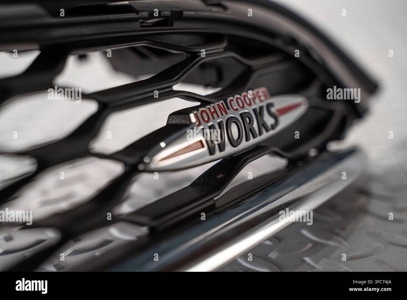 Prima vista di un badge del modello MINI John Cooper Works montato su una griglia a rete nera per autoveicoli. Foto Stock