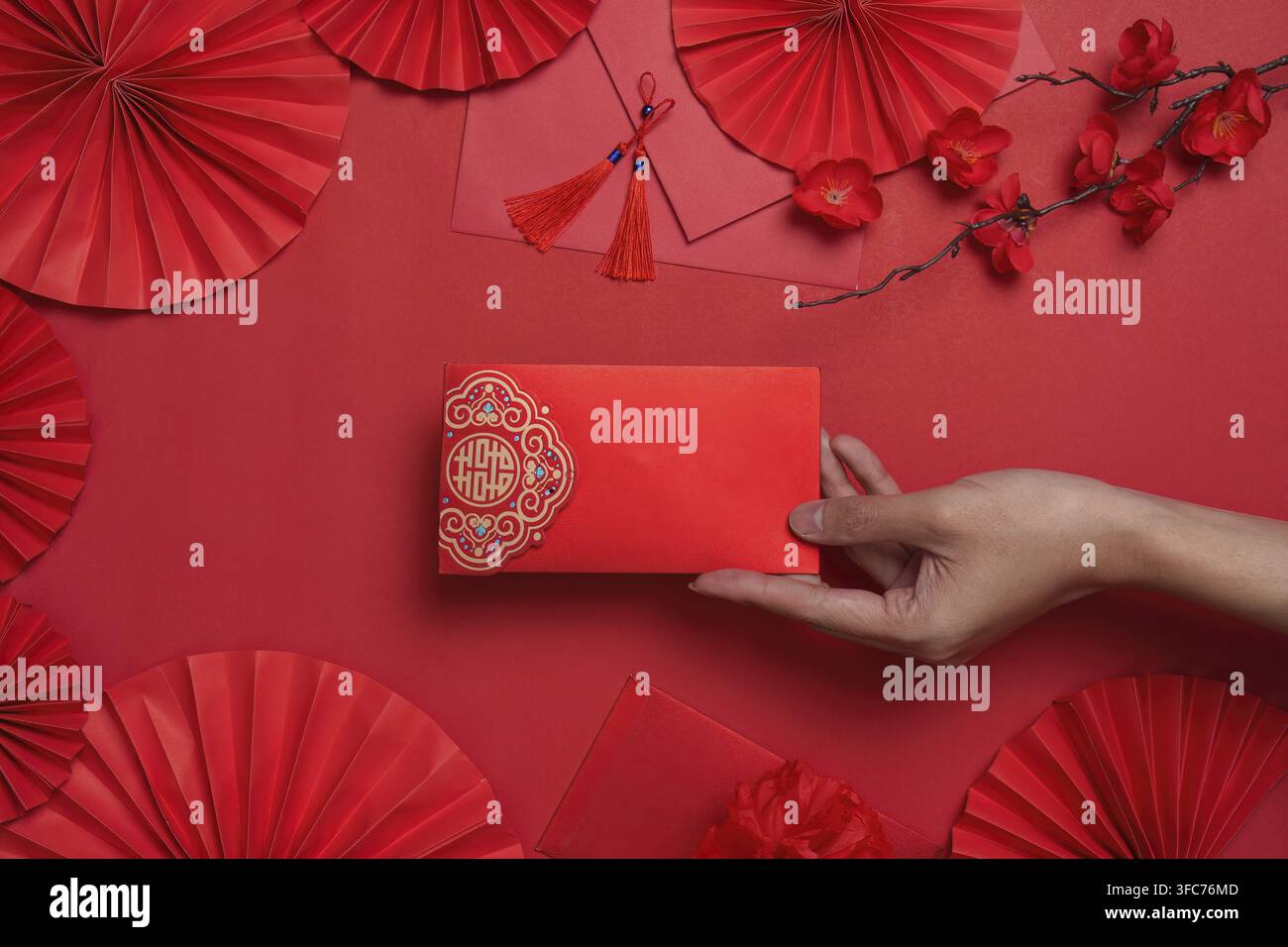 Elegante busta rossa circondata da elementi decorativi che rappresentano la tradizione e la buona fortuna per il Capodanno cinese Foto Stock