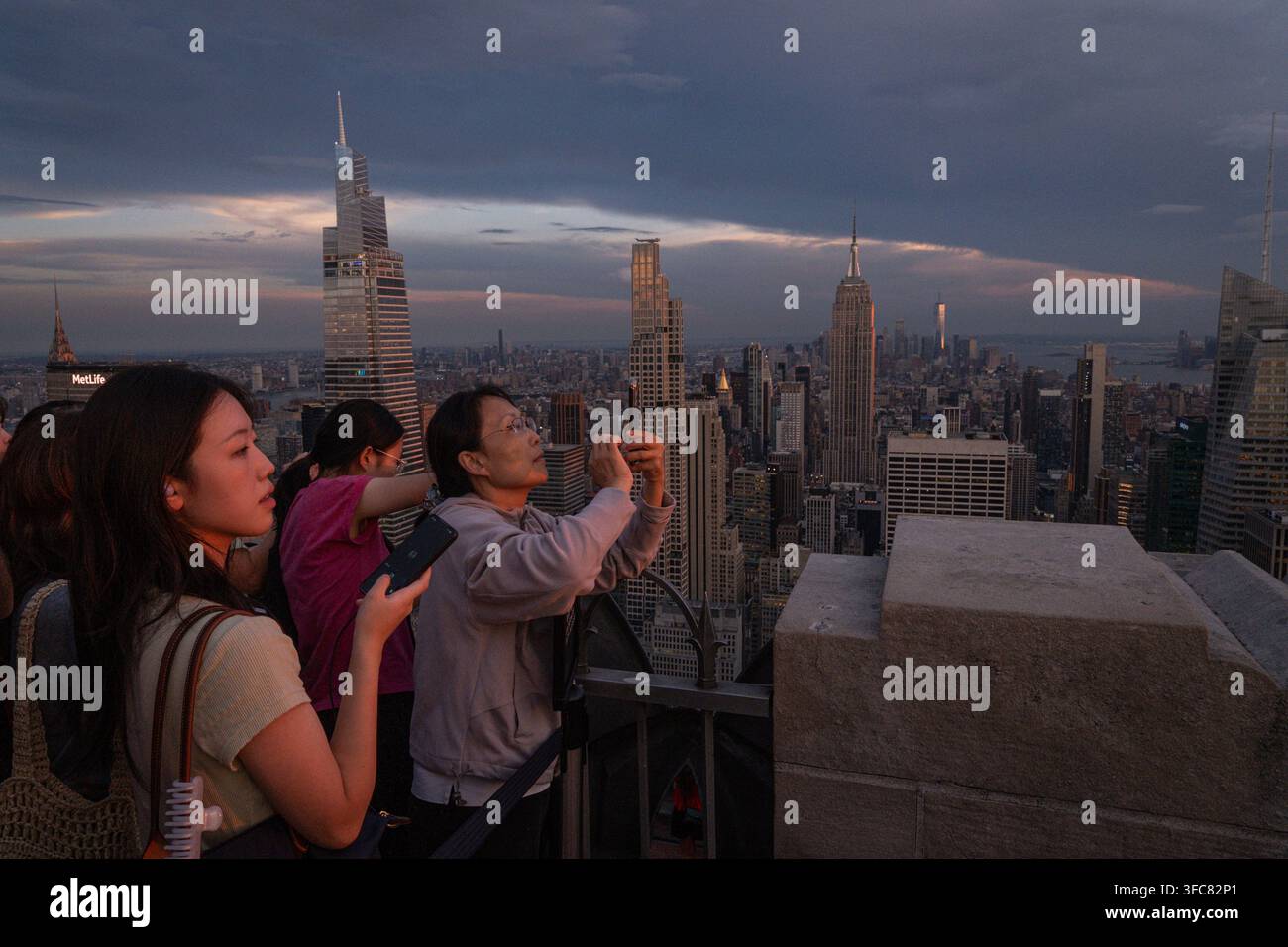 I visitatori fotografano il panorama di Midtown alla fine della giornata. New York, New York, Stati Uniti, 17 agosto 2026. Foto Stock