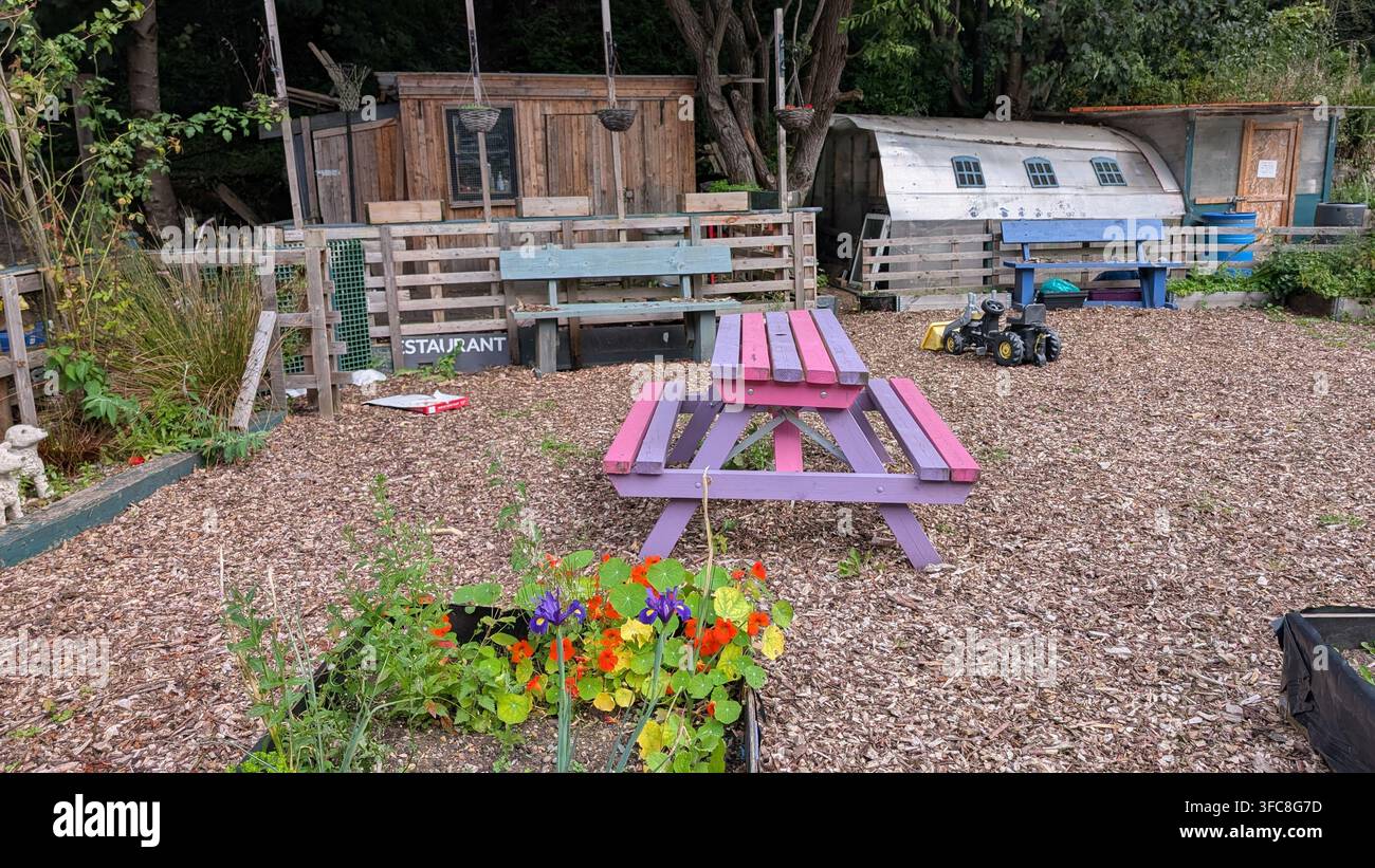 Un orto comunitario rustico o un terreno di coltura con un piccolo capanno di legno e una serra in polietilene a Maryhill, Glasgow. Foto Stock