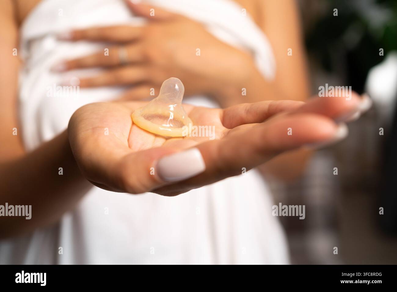 Concetto di aiuto, medicina e assistenza sanitaria. Donna che tiene un preservativo senza confezione e lo mostra alla telecamera. Spazio di copia Foto Stock
