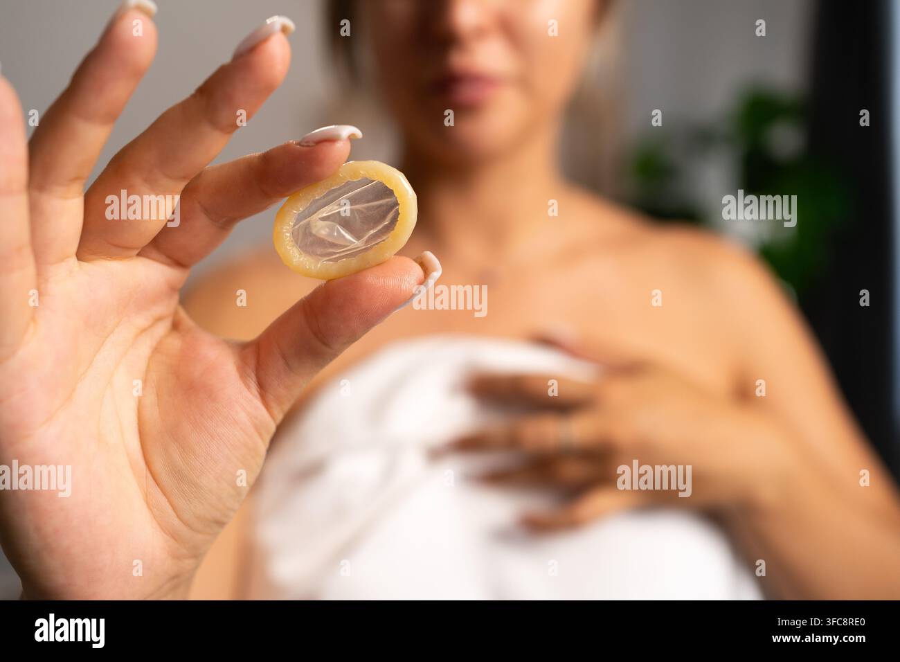 Concetto di aiuto, medicina e assistenza sanitaria. Donna che tiene un preservativo senza confezione e lo mostra alla telecamera. Spazio di copia Foto Stock