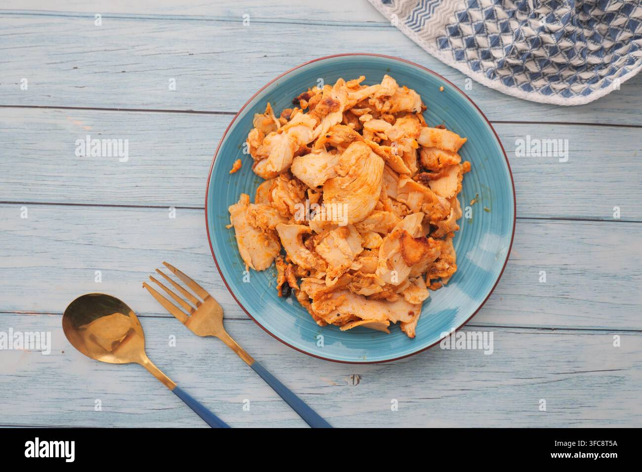 Fetta di döner di pollo su un piatto blu con posate Foto Stock