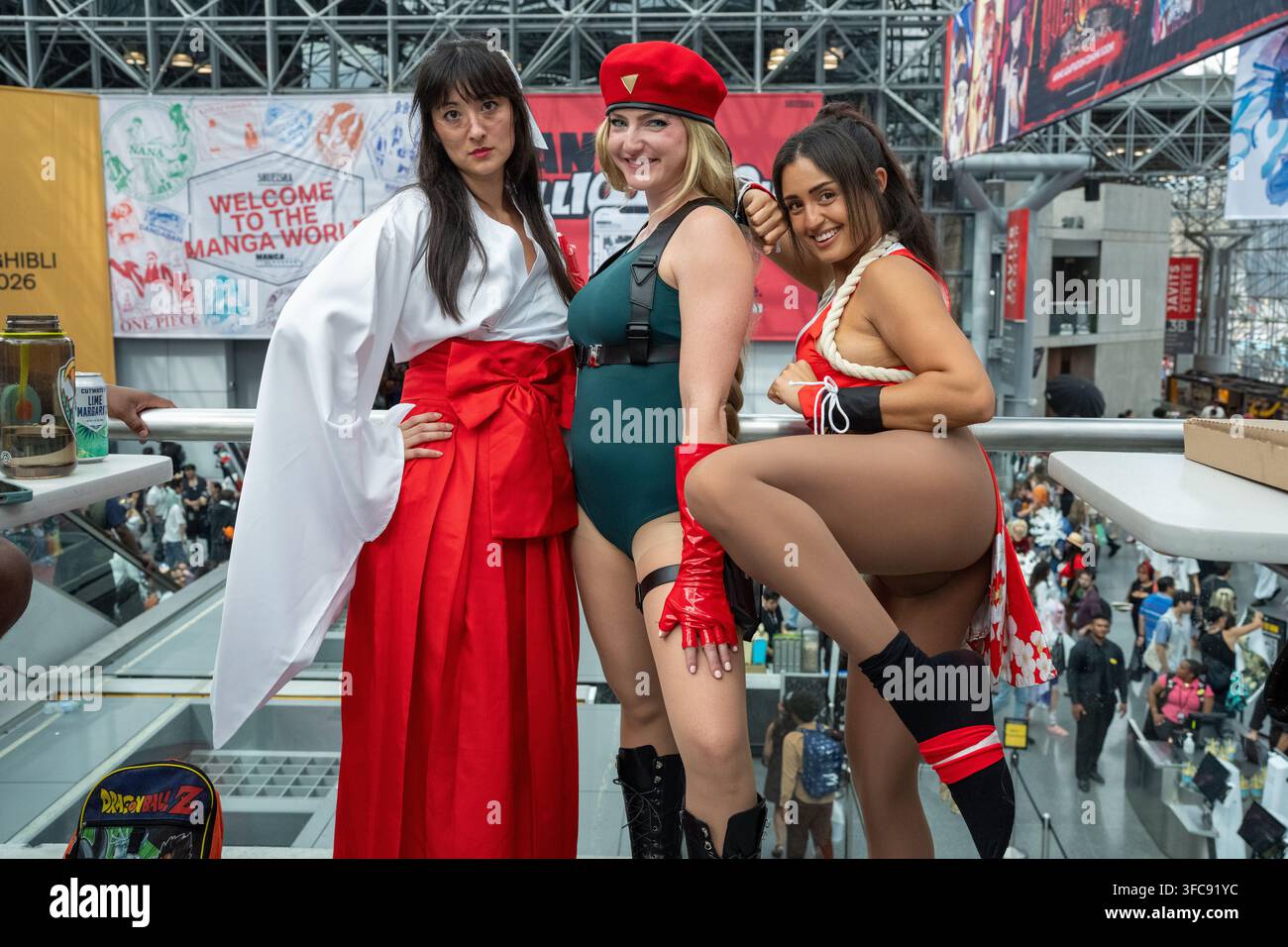 Tre cosplayer posano a un evento, uno in un abito bianco e rosso, un altro in una tutina verde e guanti rossi, e il terzo in un abito rosso e bianco con una corda. Foto Stock