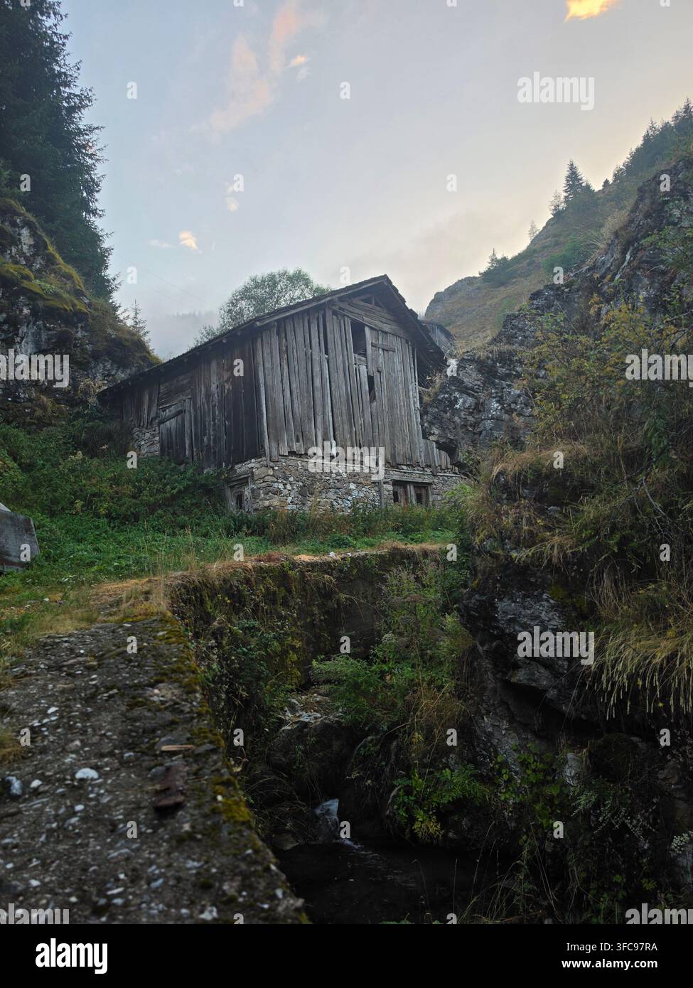 Stalla tradizionale in legno nel remoto villaggio di montagna di Mugla, Monti Rodopi, Bulgaria - Immagine stock catturata con smartphone