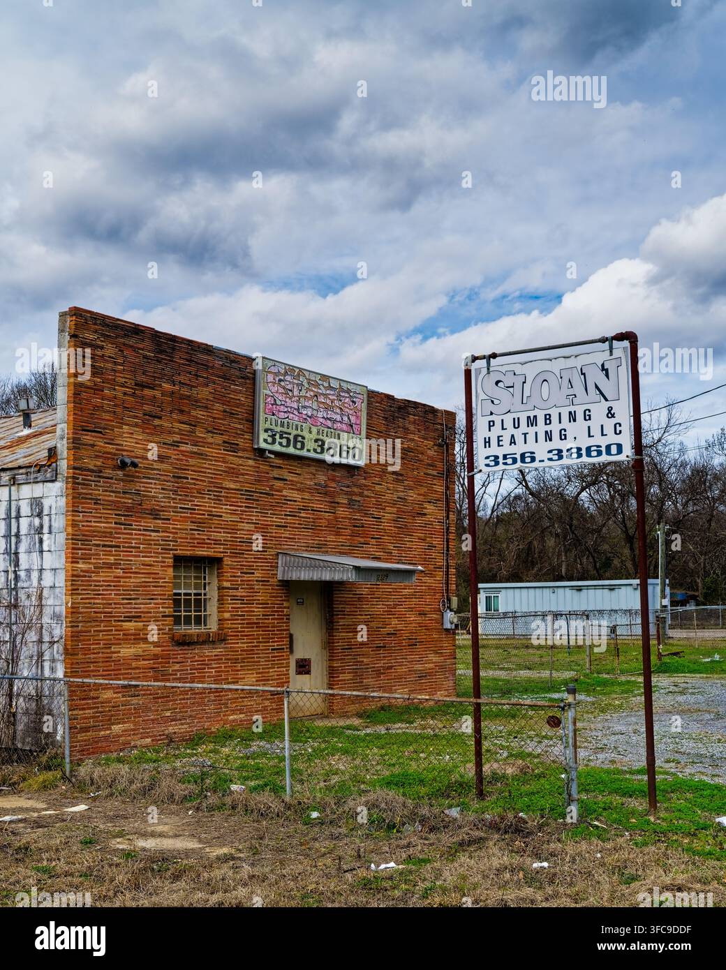 Facciata anteriore di un vecchio edificio in mattoni rossi vintage una volta occupato da Sloan Plumbing, ora abbandonato a Montgomery, Alabama, USA. Foto Stock