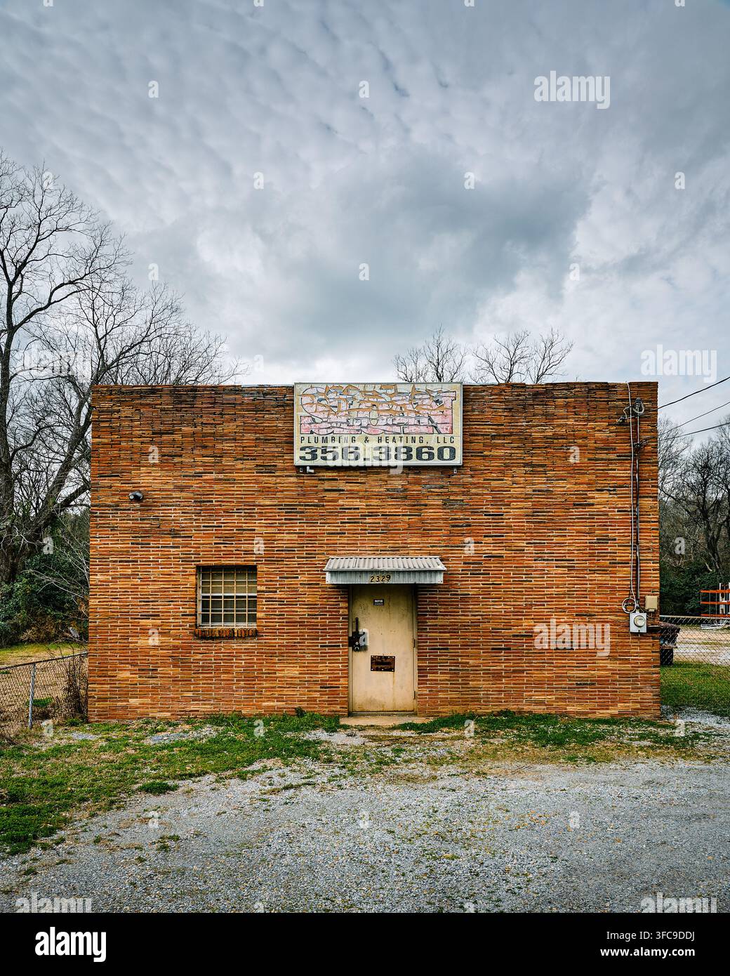 Facciata anteriore di un vecchio edificio in mattoni rossi vintage una volta occupato da Sloan Plumbing, ora abbandonato a Montgomery, Alabama, USA. Foto Stock