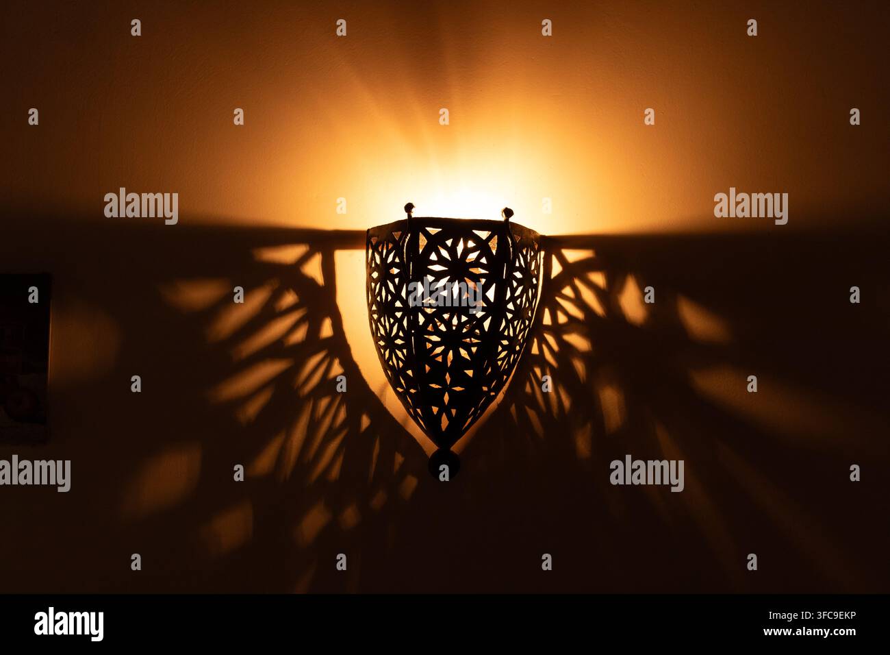 Lampa che crea un'ombra a motivi sul muro Foto Stock